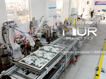 An employee operates an AI intelligent dyeing robot to produce intangible cultural heritage tie-dyeing products in a workshop in Hai'an, Jia...