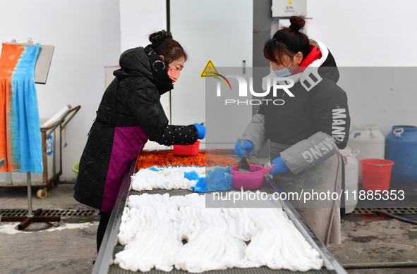 An employee operates an AI intelligent dyeing robot to produce intangible cultural heritage tie-dyeing products in a workshop in Hai'an, Jia...