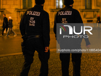 Two police officers conduct foot patrol during the evening in Munich, Bavaria, Germany, on December 20, 2024. (