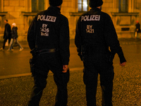 Two police officers conduct foot patrol during the evening in Munich, Bavaria, Germany, on December 20, 2024. (