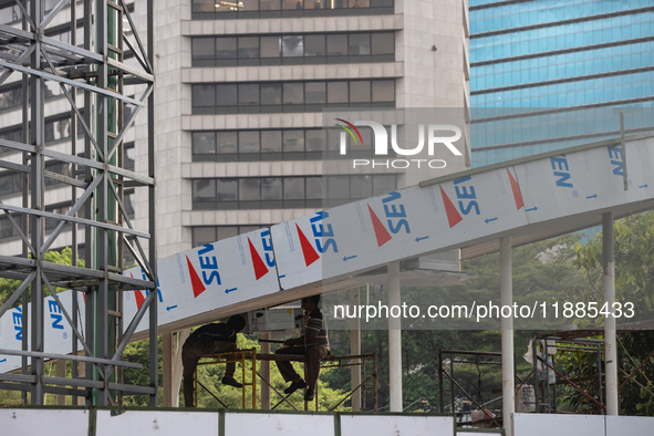 Workers complete the construction of a building's roof in Jakarta, Indonesia, on December 21, 2024. The government raises the Value Added Ta...