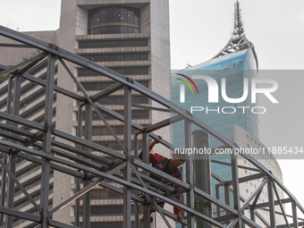 Workers complete the construction of a building's roof in Jakarta, Indonesia, on December 21, 2024. The government raises the Value Added Ta...