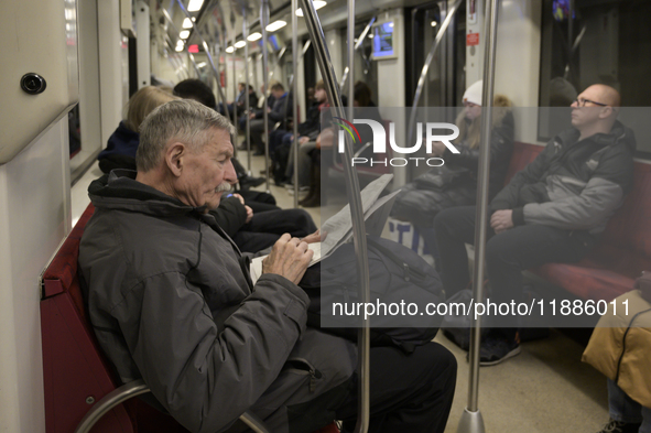 A man reads a newspaper in the metro in Warsaw, Poland, on December 21, 2024. 