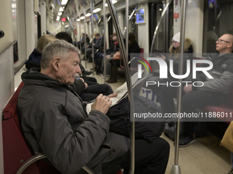 A man reads a newspaper in the metro in Warsaw, Poland, on December 21, 2024. (