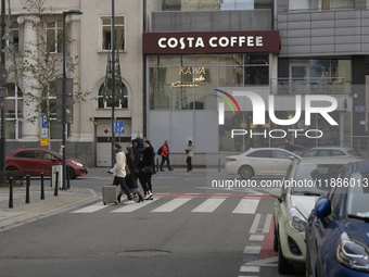 People walk past a Costa Coffee in Warsaw, Poland, on December 21, 2024. (