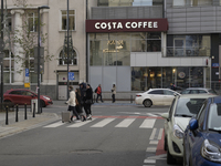 People walk past a Costa Coffee in Warsaw, Poland, on December 21, 2024. (