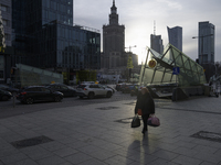 A woman walks on the sidewalk with the Palace of Culture and Science in the background in Warsaw, Poland, on December 21, 2024. (