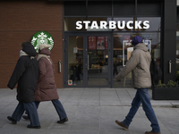 People walk past a Starbucks coffee shop in Warsaw, Poland, on December 21, 2024. (