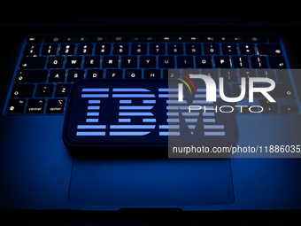 A laptop keyboard and IBM logo displayed on a smartphone are seen in this illustration photo taken in Krakow, Poland on December 21, 2024. (