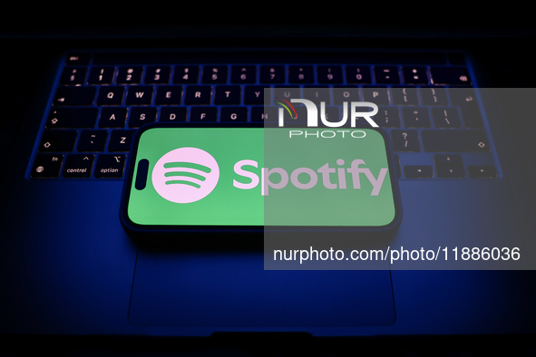 A laptop keyboard and Spotify logo displayed on a smartphone are seen in this illustration photo taken in Krakow, Poland on December 21, 202...