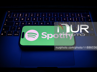 A laptop keyboard and Spotify logo displayed on a smartphone are seen in this illustration photo taken in Krakow, Poland on December 21, 202...