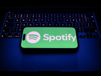 A laptop keyboard and Spotify logo displayed on a smartphone are seen in this illustration photo taken in Krakow, Poland on December 21, 202...