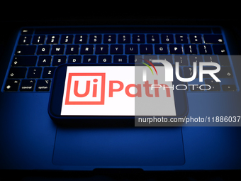 A laptop keyboard and UiPath logo displayed on a smartphone are seen in this illustration photo taken in Krakow, Poland on December 21, 2024...