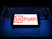 A laptop keyboard and UiPath logo displayed on a smartphone are seen in this illustration photo taken in Krakow, Poland on December 21, 2024...