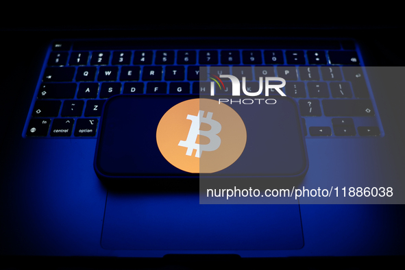 A laptop keyboard and Bitcoin logo displayed on a smartphone are seen in this illustration photo taken in Krakow, Poland on December 21, 202...