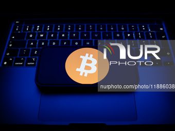 A laptop keyboard and Bitcoin logo displayed on a smartphone are seen in this illustration photo taken in Krakow, Poland on December 21, 202...