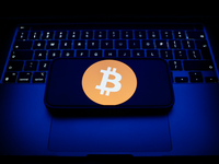 A laptop keyboard and Bitcoin logo displayed on a smartphone are seen in this illustration photo taken in Krakow, Poland on December 21, 202...