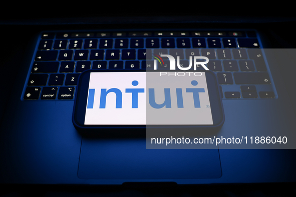 A laptop keyboard and Intuit logo displayed on a smartphone are seen in this illustration photo taken in Krakow, Poland on December 21, 2024...