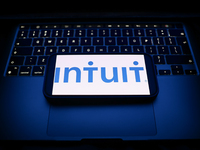 A laptop keyboard and Intuit logo displayed on a smartphone are seen in this illustration photo taken in Krakow, Poland on December 21, 2024...