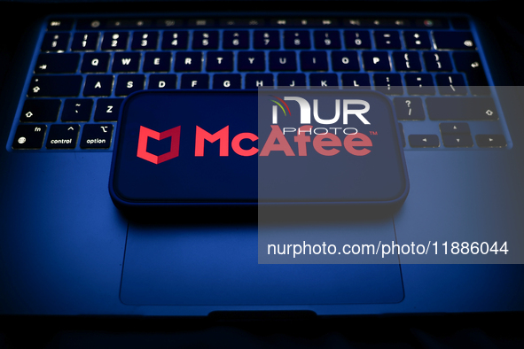 A laptop keyboard and McAfee logo displayed on a smartphone are seen in this illustration photo taken in Krakow, Poland on December 21, 2024...