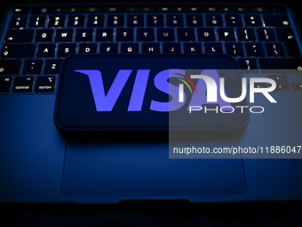 A laptop keyboard and Visa logo displayed on a smartphone are seen in this illustration photo taken in Krakow, Poland on December 21, 2024....