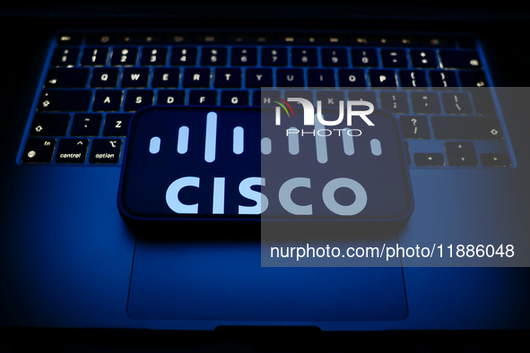 A laptop keyboard and Cisco logo displayed on a smartphone are seen in this illustration photo taken in Krakow, Poland on December 21, 2024....