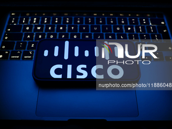 A laptop keyboard and Cisco logo displayed on a smartphone are seen in this illustration photo taken in Krakow, Poland on December 21, 2024....