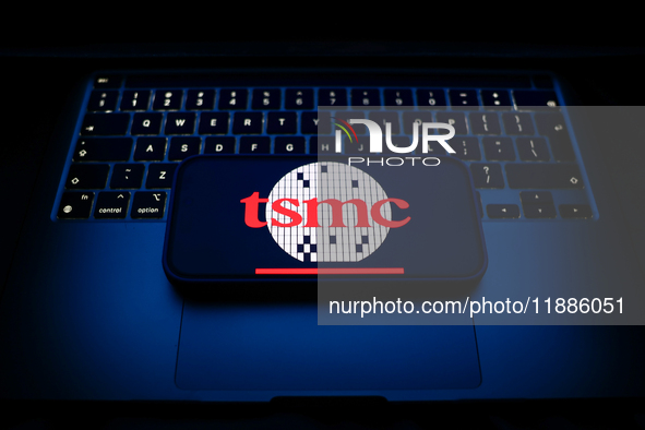 A laptop keyboard and TSMC logo displayed on a smartphone are seen in this illustration photo taken in Krakow, Poland on December 21, 2024. 