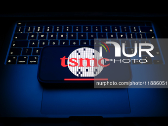 A laptop keyboard and TSMC logo displayed on a smartphone are seen in this illustration photo taken in Krakow, Poland on December 21, 2024....