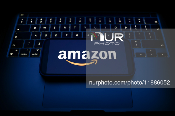 A laptop keyboard and Amazon logo displayed on a smartphone are seen in this illustration photo taken in Krakow, Poland on December 21, 2024...