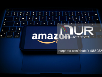 A laptop keyboard and Amazon logo displayed on a smartphone are seen in this illustration photo taken in Krakow, Poland on December 21, 2024...