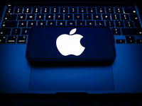 A laptop keyboard and Apple logo displayed on a smartphone are seen in this illustration photo taken in Krakow, Poland on December 21, 2024....