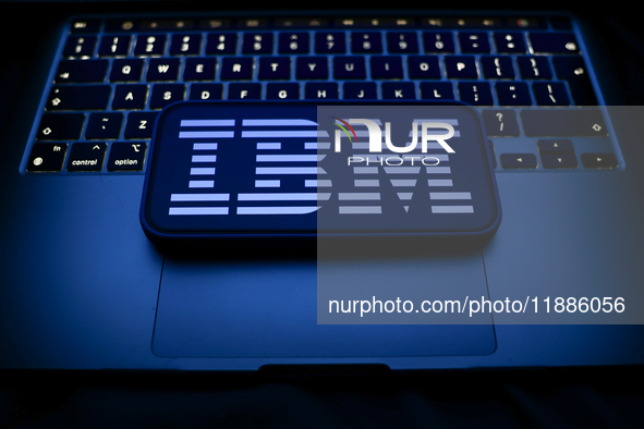 A laptop keyboard and IBM logo displayed on a smartphone are seen in this illustration photo taken in Krakow, Poland on December 21, 2024. 