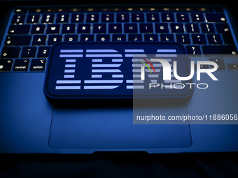 A laptop keyboard and IBM logo displayed on a smartphone are seen in this illustration photo taken in Krakow, Poland on December 21, 2024. (