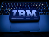 A laptop keyboard and IBM logo displayed on a smartphone are seen in this illustration photo taken in Krakow, Poland on December 21, 2024. (