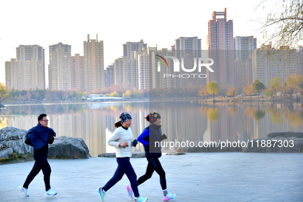 People run for fitness in low temperatures at Donghu Park in Zaozhuang, East China's Shandong province, on December 21, 2024. 