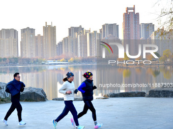 People run for fitness in low temperatures at Donghu Park in Zaozhuang, East China's Shandong province, on December 21, 2024. (