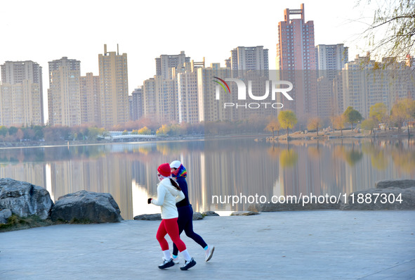 People run for fitness in low temperatures at Donghu Park in Zaozhuang, East China's Shandong province, on December 21, 2024. 