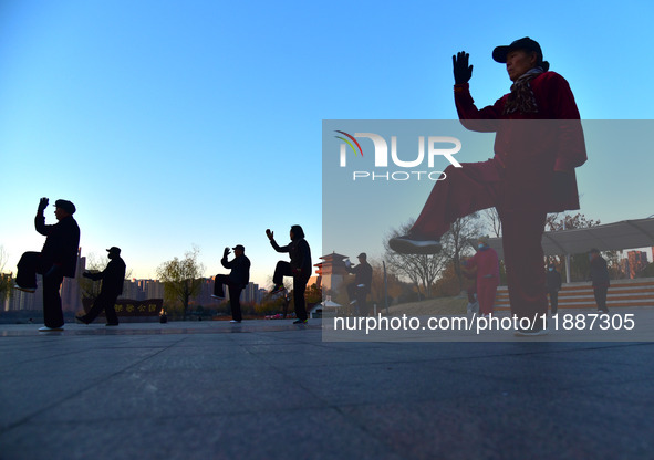 Fitness enthusiasts practice tai chi in low temperatures at Donghu Park in Zaozhuang City, East China's Shandong Province, on December 21, 2...