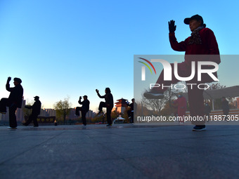 Fitness enthusiasts practice tai chi in low temperatures at Donghu Park in Zaozhuang City, East China's Shandong Province, on December 21, 2...