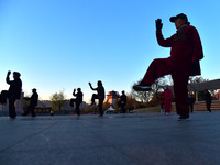 Fitness enthusiasts practice tai chi in low temperatures at Donghu Park in Zaozhuang City, East China's Shandong Province, on December 21, 2...