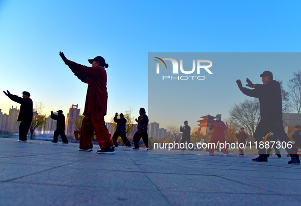 Fitness enthusiasts practice tai chi in low temperatures at Donghu Park in Zaozhuang City, East China's Shandong Province, on December 21, 2...