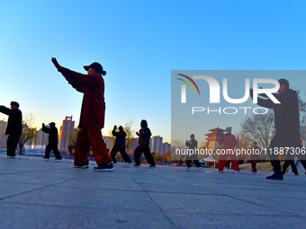 Fitness enthusiasts practice tai chi in low temperatures at Donghu Park in Zaozhuang City, East China's Shandong Province, on December 21, 2...