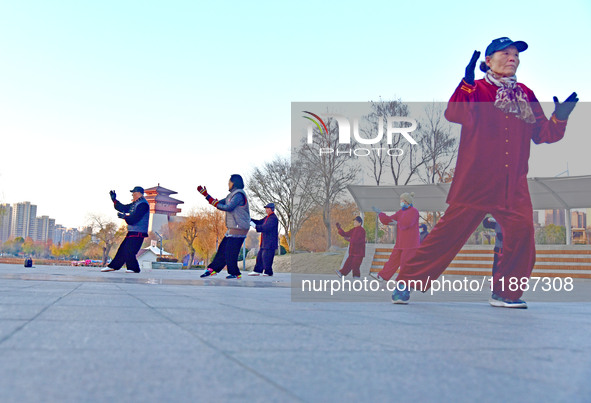 Fitness enthusiasts practice tai chi in low temperatures at Donghu Park in Zaozhuang City, East China's Shandong Province, on December 21, 2...