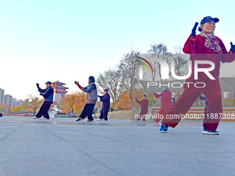 Fitness enthusiasts practice tai chi in low temperatures at Donghu Park in Zaozhuang City, East China's Shandong Province, on December 21, 2...