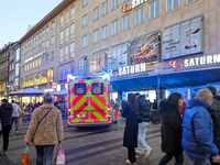 In Munich, Germany, on December 28, 2024, a Johanniter rescue vehicle with flashing blue lights parks on the shopping street Kaufinger Stras...