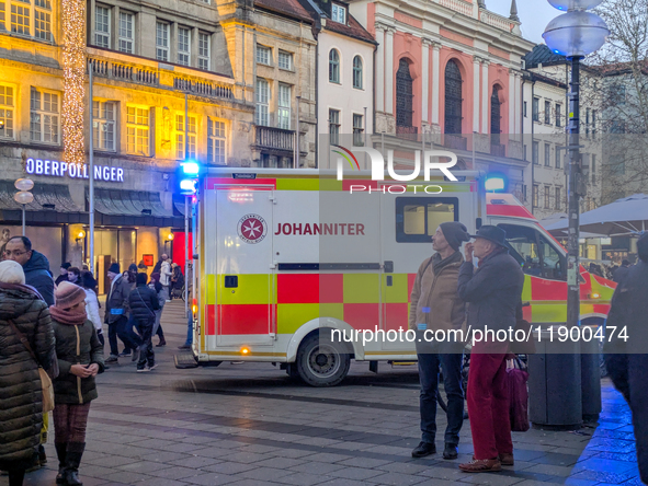 In Munich, Germany, on December 28, 2024, a Johanniter rescue vehicle with flashing blue lights parks on the shopping street Kaufinger Stras...