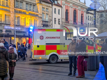 In Munich, Germany, on December 28, 2024, a Johanniter rescue vehicle with flashing blue lights parks on the shopping street Kaufinger Stras...