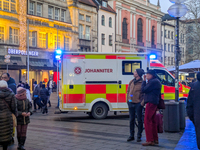 In Munich, Germany, on December 28, 2024, a Johanniter rescue vehicle with flashing blue lights parks on the shopping street Kaufinger Stras...