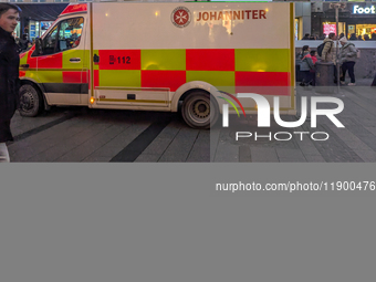 In Munich, Germany, on December 28, 2024, a Johanniter rescue vehicle with flashing blue lights parks on the shopping street Kaufinger Stras...